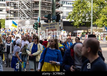Des centaines d'Ukrainiens et de sympathisants se sont rassemblés près de l'église commémorative Kaiser Wilhelm à Berlin le dimanche 24 août 2025, pour marquer le jour de l'indépendance de l'Ukraine, agitant des drapeaux bleus et jaunes et tenant des pancartes qualifiant la Russie d'"État terroriste". Les manifestants scandaient et portaient des pancartes exigeant un soutien militaire occidental accru, y compris la livraison de missiles de croisière Taurus à l'Ukraine, et exhortant la Russie à restituer les enfants enlevés des territoires occupés. Oleksii Makeiev, ambassadeur de l'Ukraine en Allemagne, s'est adressé à la foule lors du rassemblement, qui a eu lieu à l'occasion du 34e anniversaire de l'Ukraine Banque D'Images