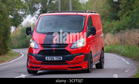 Whittlebury, Norhants, Royaume-Uni - 23 août 2025 : 2016 Red Ford transit base personnalisée Panther van conduisant sur une route britannique Banque D'Images