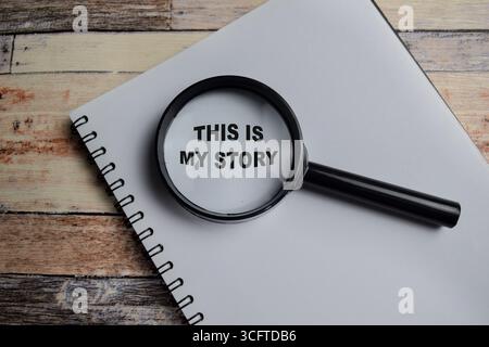 Concept de cette mon histoire écrire sur le livre avec la loupe isolé sur la table en bois. Banque D'Images