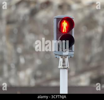 Feu rouge pour piétons montrant une figure debout, gros plan sur fond flou. Banque D'Images