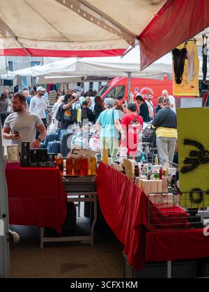 Cremona, Italie- 23 août 2025 animée scène de marché extérieur dans l'Italie historique de Crémone avec divers vendeurs et acheteurs sous la tente blanche Banque D'Images