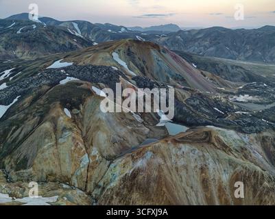 Vue aérienne du paysage saisissant des Highlands, où les montagnes colorées rencontrent les vestiges glaciaires sous un vaste ciel, créant une vue imprenable sur IC Banque D'Images