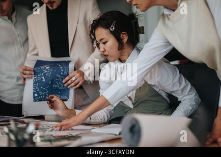 Groupe de personnes collaborant sur un projet architectural dans un bureau moderne Banque D'Images