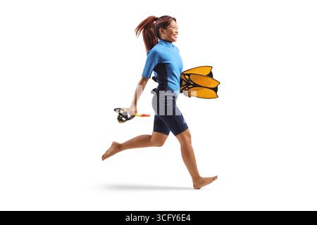 Femme dans une combinaison de plongée courant et tenant des ailerons de natation isolés sur fond blanc Banque D'Images