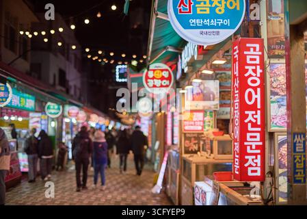 Marché de rue nocturne avec des enseignes colorées au néon à Busan, Corée du Sud, le 15 février 2023 Banque D'Images