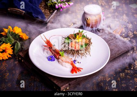 Crevette botan et Uni Sashimi plaqué avec coquille d'oursin et fleurs comestibles Banque D'Images