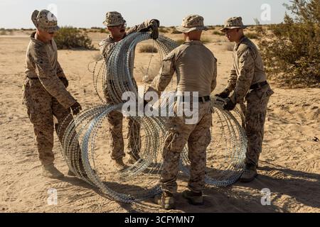 Yuma, États-Unis. 19 août 2025. Les Marines des États-Unis avec le bataillon de logistique de combat 15, le régiment de logistique de combat 17, 1st Marine Logistics Group, affecté à la joint Task Force-Southern Border, organisent des faisceaux de fils de concertina avant de les installer le long du mur de la frontière sud avec le Mexique, le 19 août 2025 près de Yuma, Arizona. Crédit : Sgt. Mary Torres/US Marines photo/Alamy Live News Banque D'Images