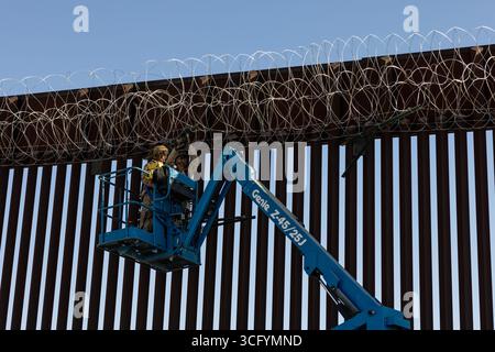 Yuma, États-Unis. 19 août 2025. Les Marines des États-Unis avec le bataillon de logistique de combat 15, le régiment de logistique de combat 17, 1st Marine Logistics Group, affecté à la joint Task Force-Southern Border, installent du fil de fer concertina le long du mur de la frontière sud avec le Mexique, le 19 août 2025 près de Yuma, Arizona. Crédit : Sgt. Mary Torres/US Marines photo/Alamy Live News Banque D'Images