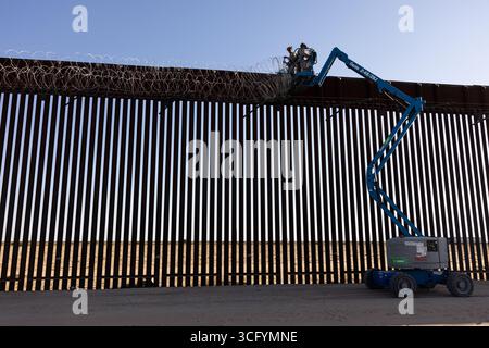 Yuma, États-Unis. 19 août 2025. Les Marines des États-Unis avec le bataillon de logistique de combat 15, le régiment de logistique de combat 17, 1st Marine Logistics Group, affecté à la joint Task Force-Southern Border, installent du fil de fer concertina le long du mur de la frontière sud avec le Mexique, le 19 août 2025 près de Yuma, Arizona. Crédit : Sgt. Mary Torres/US Marines photo/Alamy Live News Banque D'Images