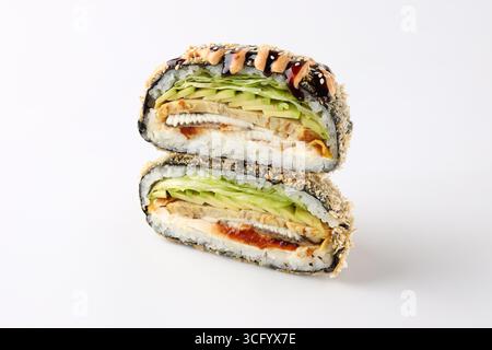Gros plan d'un sandwich à sushi onigirazu frit rempli d'anguille grillée (unagi), d'avocat, de laitue fraîche et de riz enveloppé dans du nori, garni de m épicé Banque D'Images