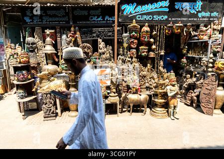 Scène intéressante de Chor Bazaar, magasins d'antiquités à Mumbai en Inde, homme en vêtements traditionnels passant magasin d'antiquités avec de nombreux articles historiques Banque D'Images