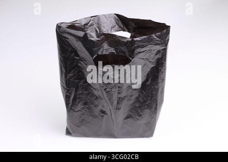 Sac en plastique noir isolé sur fond blanc. Banque D'Images