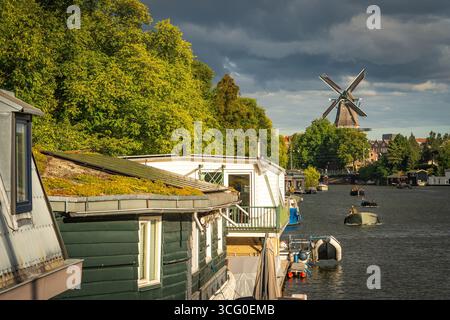 Moulin à vent de Gooyer à Amsterdam avec des péniches le long du canal, emblématique monument hollandais Banque D'Images