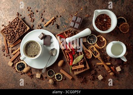 Diverses épices et assaisonnements pour faire des boissons aromatiques à base de café. Café noir dans une tasse blanche. Vue de dessus. Banque D'Images