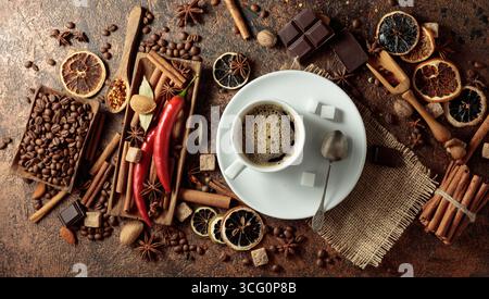 Diverses épices et assaisonnements pour faire des boissons aromatiques à base de café. Café noir dans une tasse blanche. Vue de dessus. Banque D'Images