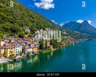 Lac de Lugano, Italie. Vue sur le lac, les montagnes et le village pittoresque. Une petite ville italienne au bord du lac à la frontière de la Suisse. Vue aérienne par drone Banque D'Images
