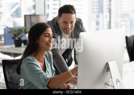 Employé féminin joyeux engagé dans une conversation positive avec un collègue masculin Banque D'Images