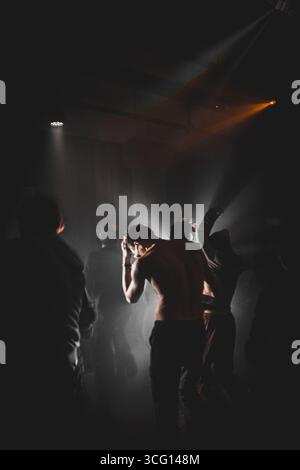 Ensemble DJ. Les gens dansent à la rave dans le noir. en fumée blanche. Disc-jockey professionnel mixant des pistes musicales. Techno dure Banque D'Images