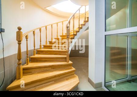 Un escalier en colimaçon en bois avec vue sur l'extérieur. L'escalier est en bois et a un design unique et incurvé. La vue depuis le sommet du stai Banque D'Images
