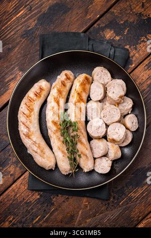 Saucisses grillées avec de la viande de forçage mincemat et des herbes dans l'assiette. fond en bois. vue de dessus. Banque D'Images