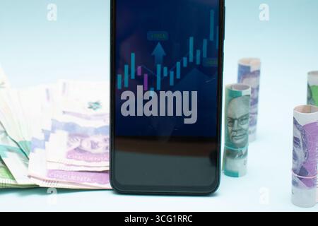 Billets de banque colombiens et graphiques financiers illustrant la croissance et le déclin économiques Banque D'Images