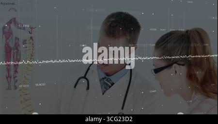 Deux professionnels de santé examinant le modèle de colonne vertébrale et pointant en salle de consultation Banque D'Images
