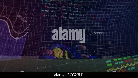 Gardien de but de plongée portant un kit bleu couché sur le gazon près du filet au stade, avec superposition numérique Banque D'Images