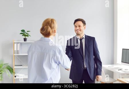 Hommes d'affaires homme et femme serrant la main, parvenir à un accord, saluer un nouveau partenaire ou employé. Banque D'Images
