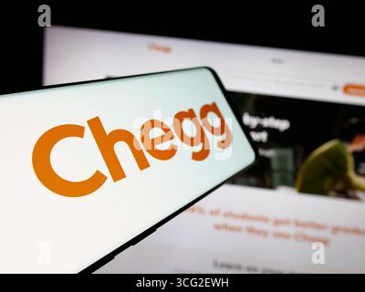 Dans cette illustration photo, un smartphone avec le logo de la société américaine de technologie éditoriale Chegg Inc est vu sur l'écran en face du site Web. Banque D'Images