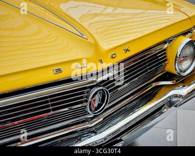 Avant du jaune Buick Electra 1962. Gros plan d'une voiture américaine pleine grandeur avec beaucoup de garnitures chromées : calandre, phare, capot et pare-chocs. Banque D'Images