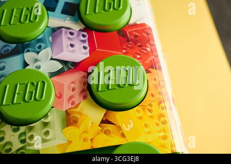 Tyumen, Russie-8 juillet 2025 : le bloc Lego de bâtiment vert repose sur un fond coloré avec des motifs ludiques Banque D'Images