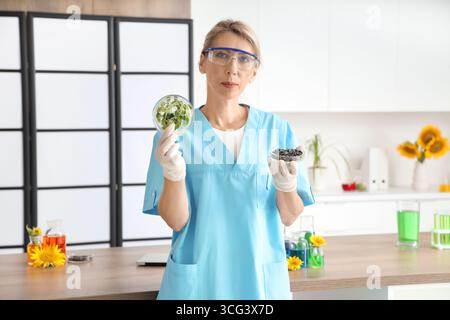 Femme scientifique avec boîte de Petri de germes de tournesol et de graines en laboratoire Banque D'Images