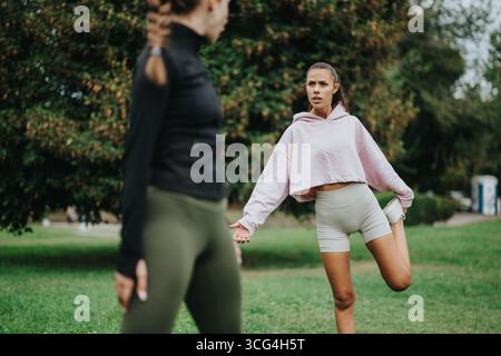 Deux femmes s'échauffant dans un parc avant leur séance d'entraînement en plein air Banque D'Images