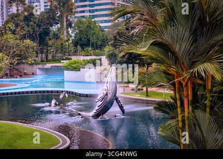 7 novembre 2019 - Kuala Lumpur, Malaisie : zone de parc KLCC avec fontaine connue sous le nom de baleine et dauphins pendant la journée. Verdure luxuriante dans le parc de la ville, mélange coloré de nature, d'art et d'architecture urbaine, immeubles résidentiels, escapade urbaine tropicale, art urbain moderne Banque D'Images