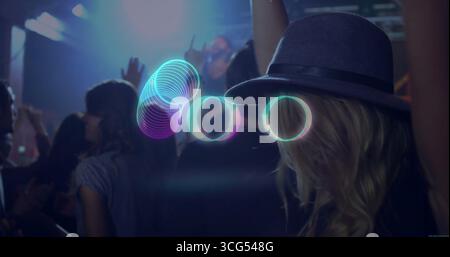 Femme interagissant portant Fedora grise manipulant des anneaux de néon dans la salle de concert, espace de copie Banque D'Images