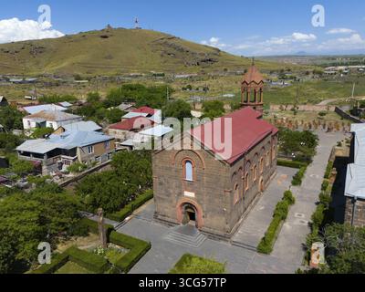 Petite église en briques dans un cadre rural avec une colline à proximité et ciel bleu, vue aérienne, église de St Mesrop Mashtots, église Mesrop Mashtots, Oskahan, OCH Banque D'Images