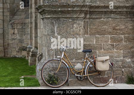Vélo féminin appuyé contre une façade d'église, Guingamp, Bretagne, France Banque D'Images