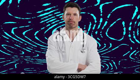Médecin masculin debout portant une blouse de laboratoire et un stéthoscope, croisant les bras en studio avec fond néon Banque D'Images