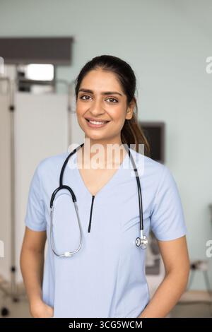Assistante médicale indienne positive en gommage posant pour portrait Banque D'Images