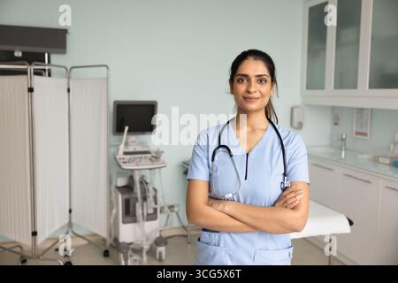 Positive confiante jeune femme médecin indienne posant pour un portrait professionnel Banque D'Images