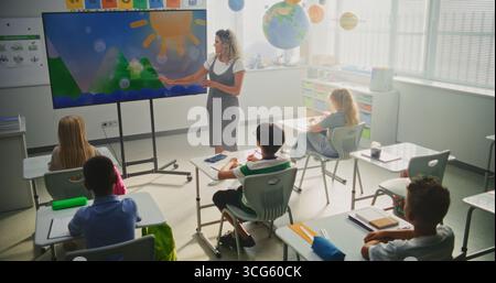 Élèves de l'école élémentaire étudiant l'information de base sur les facteurs météorologiques dans la salle de classe moderne. Enseignante expliquant les cycles de l'eau aux Smart Kids pendant la leçon de géographie à l'aide de l'écran numérique. Banque D'Images