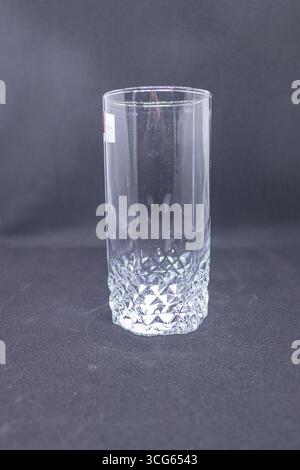 Gros plan d'un verre transparent avec une base texturée en forme de losange. Design élégant des verres avec motifs complexes, parfait pour les boissons. Banque D'Images