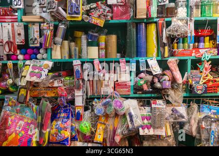 Papeterie colorée et articles ménagers soigneusement disposés sur une étagère de magasin. Un présentoir de vente dynamique présentant des fournitures scolaires, des articles de bureau essentiels et des articles de Banque D'Images