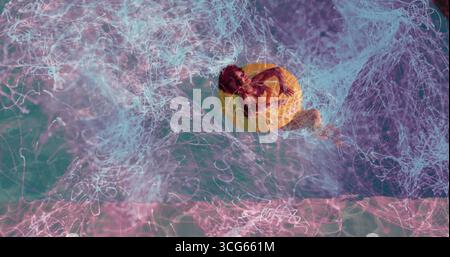 Femme noire couchée dérivant sur l'anneau gonflable jaune sur l'eau turquoise, tourbillonnant des pistes de néon Banque D'Images