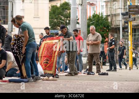 Des hommes musulmans organisent des tapis de prière près de la mosquée Banya Bashi à Sofia, en Bulgarie, pour préparer la prière du vendredi de midi. La scène reflète le culte islamique Banque D'Images