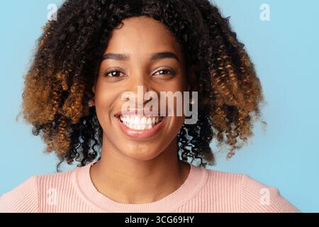 Portrait de belle jeune femme noire heureuse avec des cheveux bouclés Banque D'Images