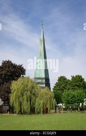 Pittoresque : Engelbert Eglise avec sa flèche distinctive au milieu d'une verdure luxuriante sous un ciel bleu serein à Odenthal, Allemagne Banque D'Images