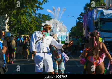 Un couple prend un selfie pendant la journée des adultes au carnaval de Notting Hill. Banque D'Images