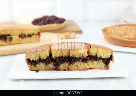 Martabak Manis, Terang Bulan ou Kue Bandung, crêpe indonésienne douce épaisse de couleur jaune et remplie de diverses garnitures. Banque D'Images
