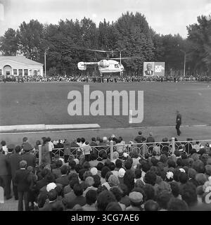 Photo d'archive du point culminant de la célébration du 300e anniversaire de Sloviansk au stade Khimik, 1976, avec un hélicoptère Ka-26 atterrissant sur le terrain devant les spectateurs, comme symbole du progrès technologique pacifique en URSS Banque D'Images